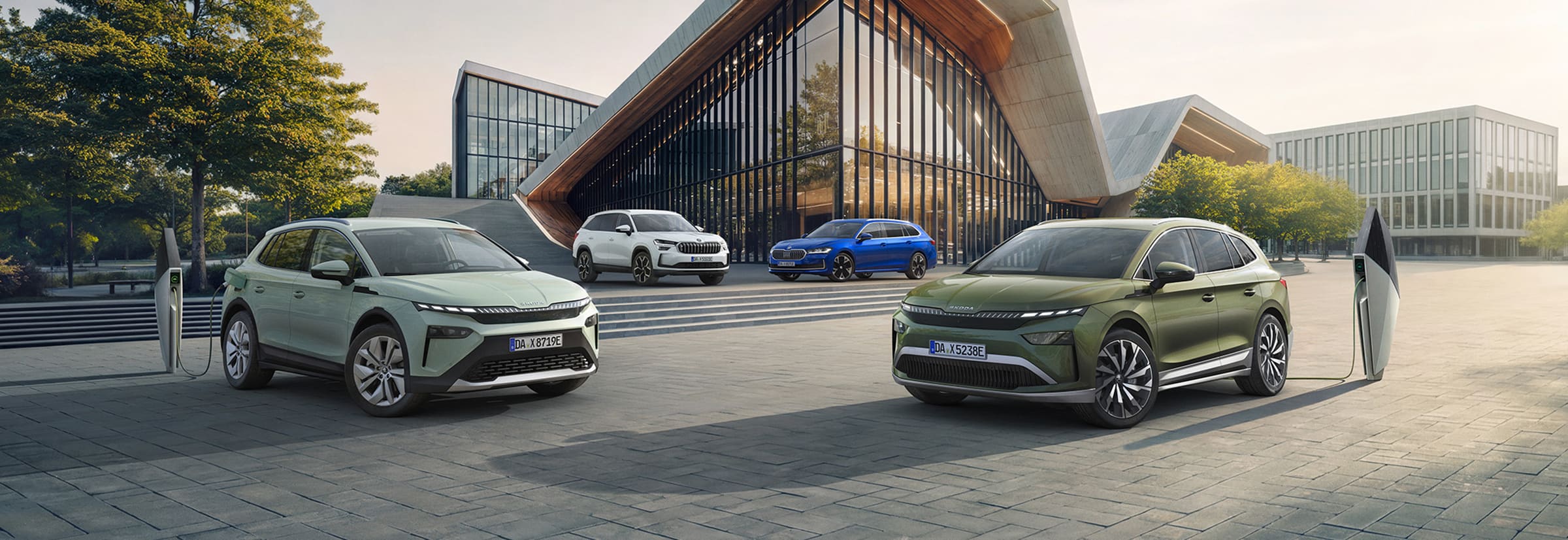 Elektrische und Plug-in-Hybrid-Modelle von Škoda vor einem modernen Bürogebäude