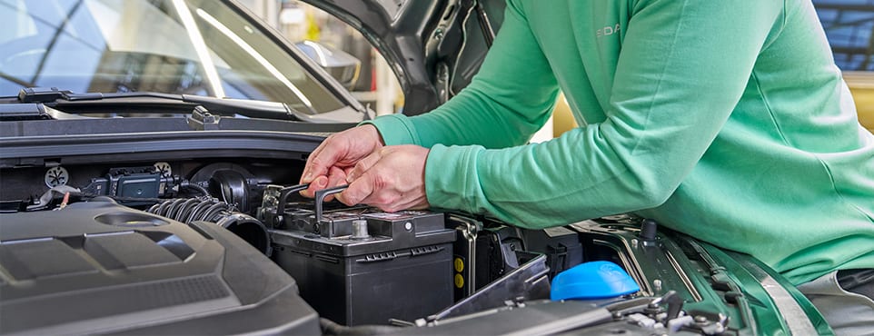 Servicetechniker prüft die Starterbatterie im Motorraum