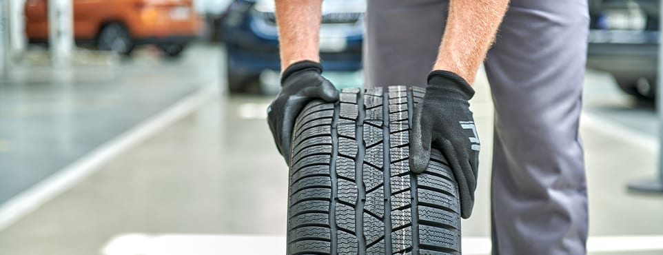 Servicetechniker hält einen Winterreifen